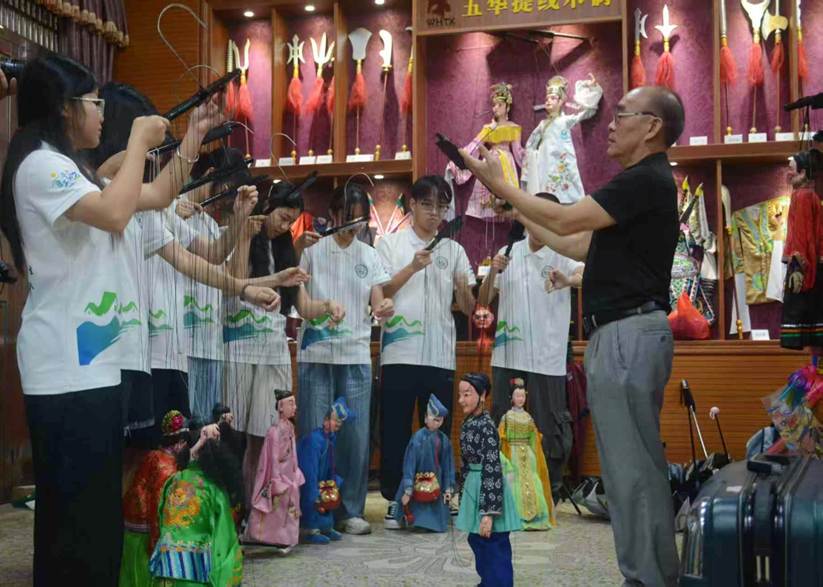 图1：国家级非遗传承人李新贤讲解提线木偶